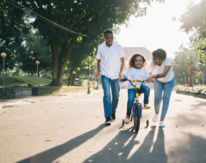 pexels-photo-1128318-1128318 Happy family teaching their child to cycle on a sunny day outdoors.