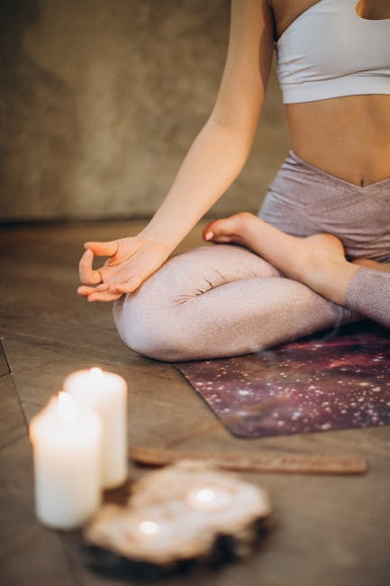 pexels-photo-3822621-3822621 A woman practicing yoga indoors in lotus pose with candles creating a calming atmosphere.